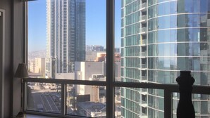 Ein Hotelzimmer mit großem Fenster und Blick auf moderne Gebäude sowie eine belebte Straße.