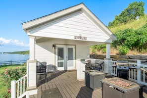 A covered outdoor area with a grill, seating, and a view of the water. - Fox Den at CrossTimbers Marina (Sperry)
