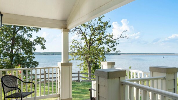 A covered porch with a view of a lake and distant hills. - Fox Den at CrossTimbers Marina (Sperry)