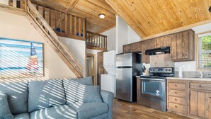 A modern kitchen with wooden cabinets, a stainless steel refrigerator, and a built-in oven. - Fox Den at CrossTimbers Marina (Sperry)