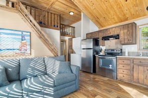 A modern kitchen with wooden cabinets, a stainless steel refrigerator, and a built-in oven. - Fox Den at CrossTimbers Marina (Sperry)