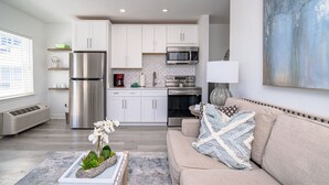 A modern kitchen with white cabinets, stainless steel appliances, and a built-in microwave. - Gulf Views!/corner unit/deeded beach access/pickleball courts (Santa Rosa Beach)