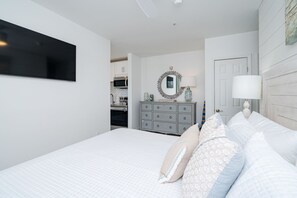 Un dormitorio con una cama grande, un aparador, un espejo y una puerta.