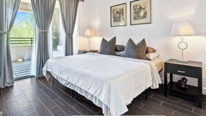 A bedroom with a large bed, two bedside tables with lamps, a ceiling fan, and two framed pictures on the wall. - WELL DRESSED GRAYHAWK CONDO! QUIET OPEN BRIGHT...Close to all the good stuff! (Scottsdale)