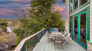 A wooden deck with outdoor furniture, a view of the surrounding area, and a building with green trim and glass doors. - Custom Built by the Littlehale Family (Julian)