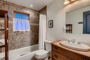 A bathroom with a bathtub, toilet, and sink. - Custom Built by the Littlehale Family (Julian)