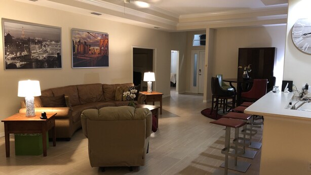 A living room with a sofa, a coffee table, and a dining area with chairs and a table. - Golfer’s Paradise 3/2 Luxury Vacation Home (Bradenton)