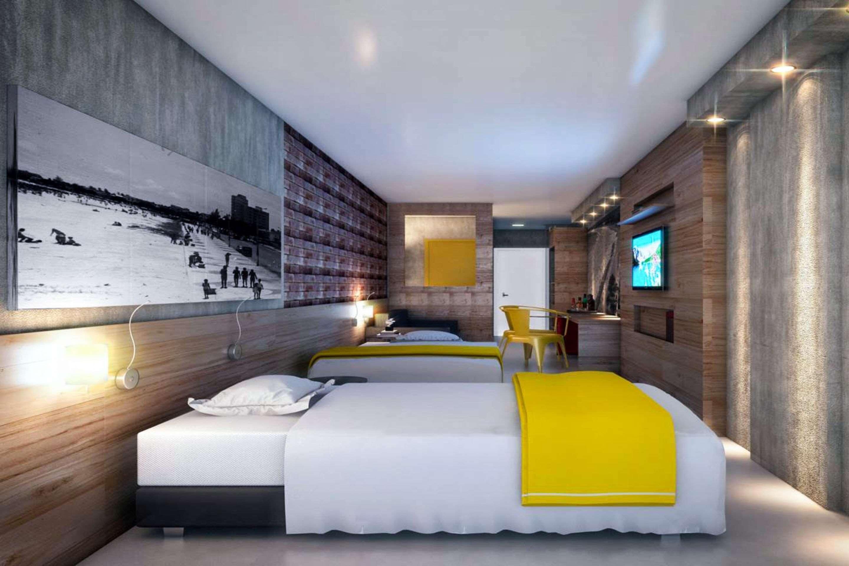 A modern hotel room with two beds, a large artwork on the wall, a television, and a desk with a chair.