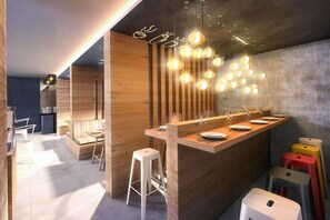 A modern kitchen with a wooden island, bar stools, and pendant lighting. - Comfort Hotel Maceio (Maceió)