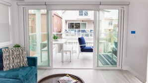 Un salon moderne avec une porte-fenêtre coulissante donnant sur un balcon.