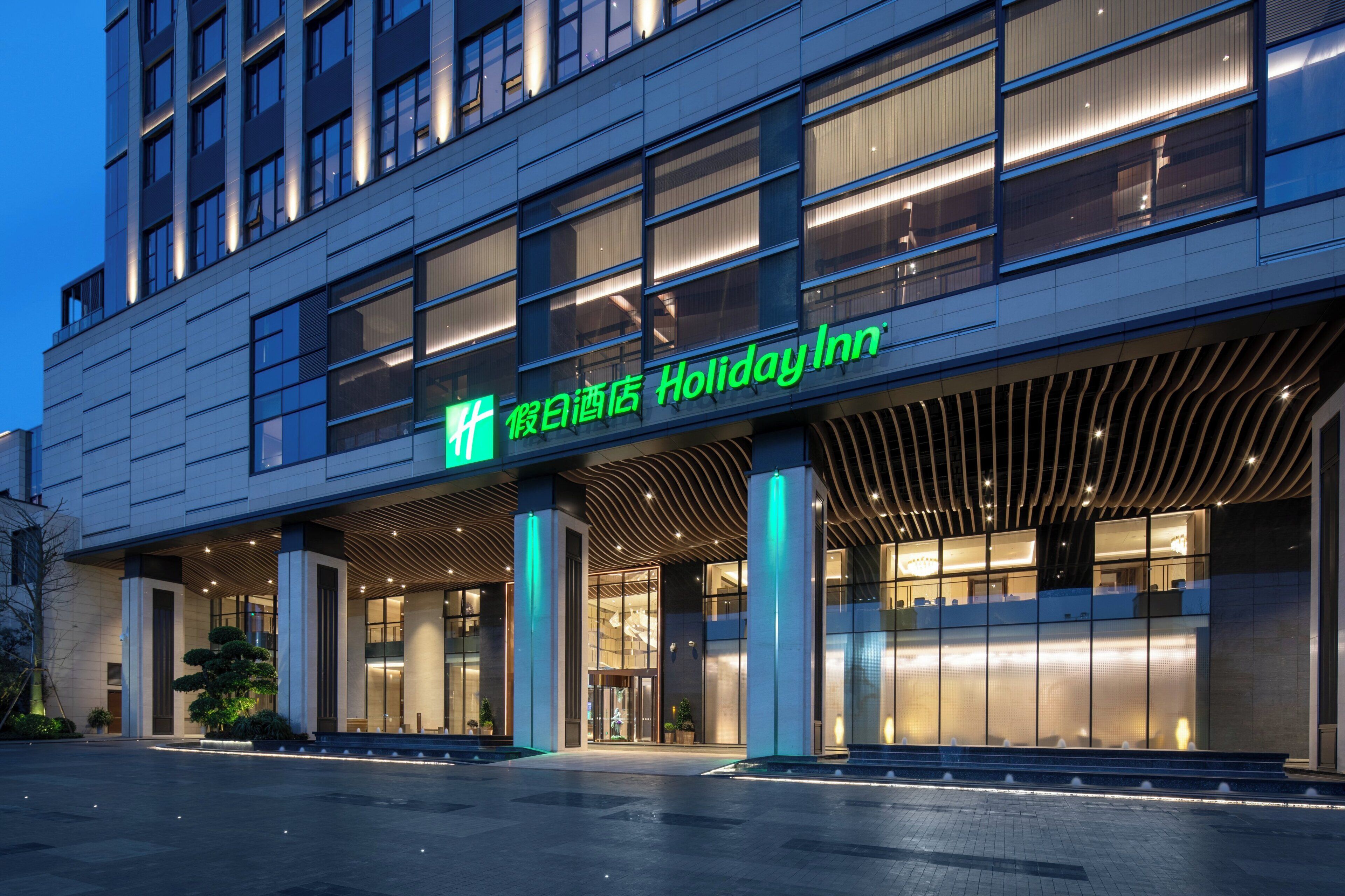 Un edificio moderno de hotel con un letrero llamativo que dice 'Holiday Inn'.