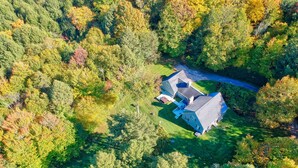 Vue aérienne d’une maison entourée d’une forêt dense.