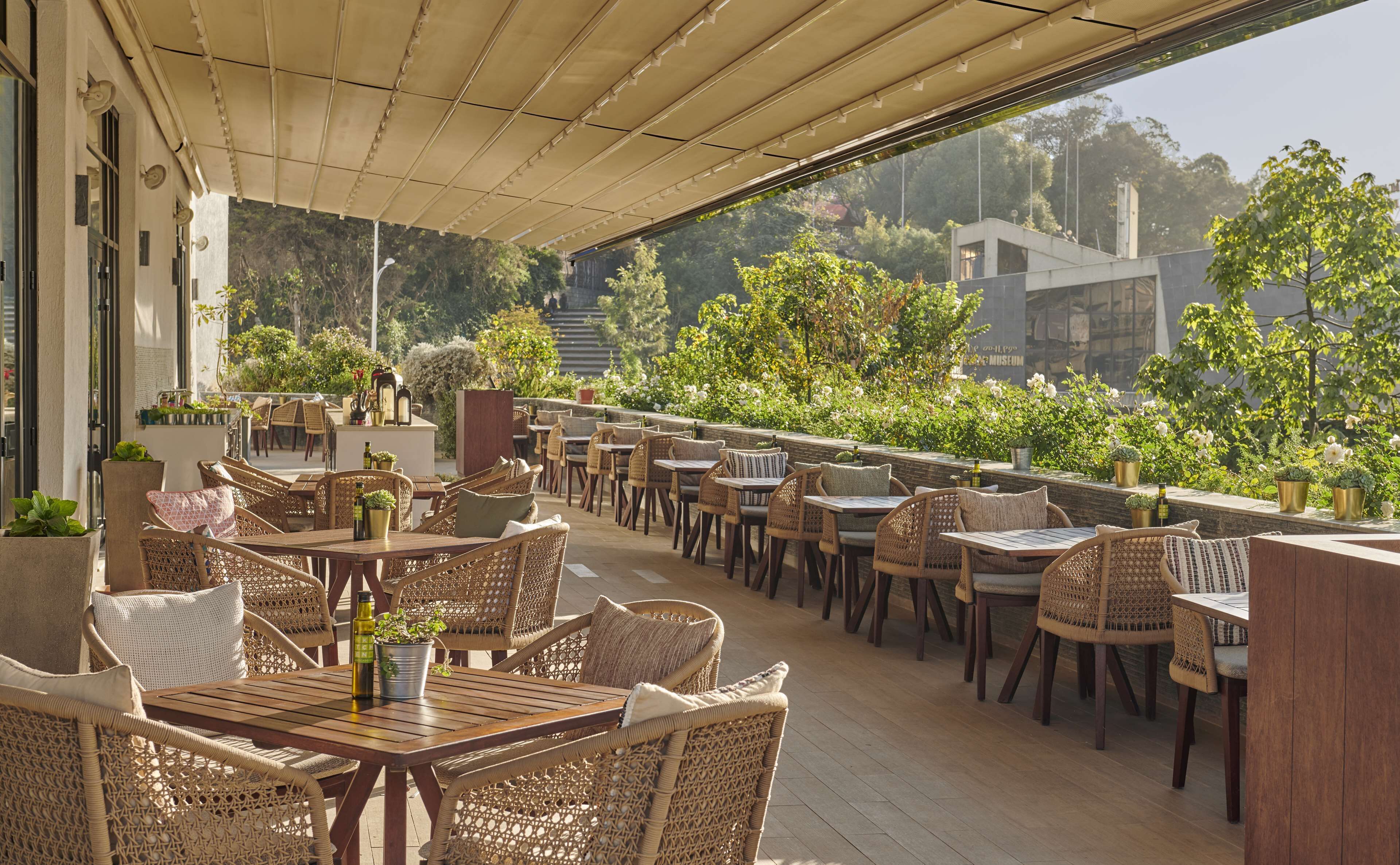 An outdoor patio with wicker furniture and a view of a museum.
