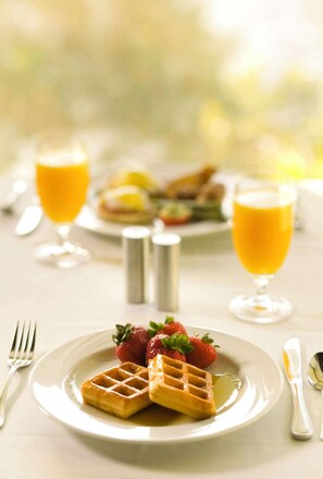 Waffles and fresh fruit served in a casual dining setting.