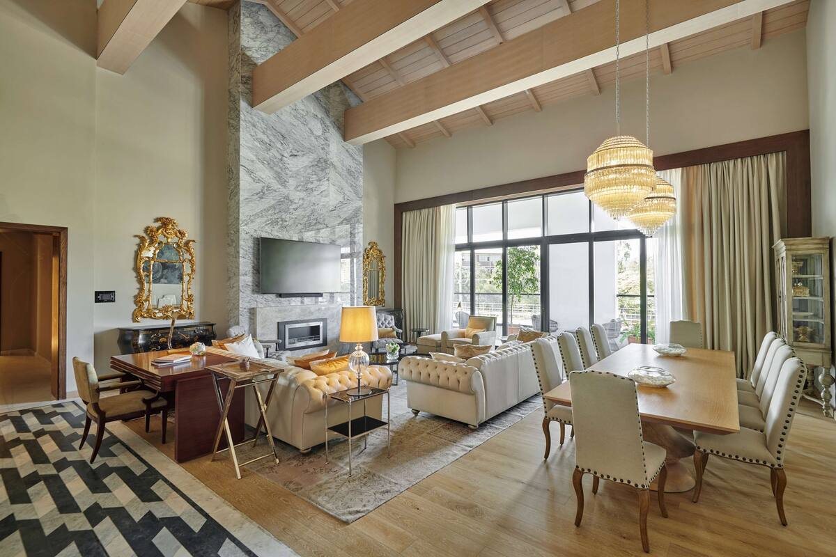 A spacious living room with a fireplace, a large dining table, and comfortable seating.