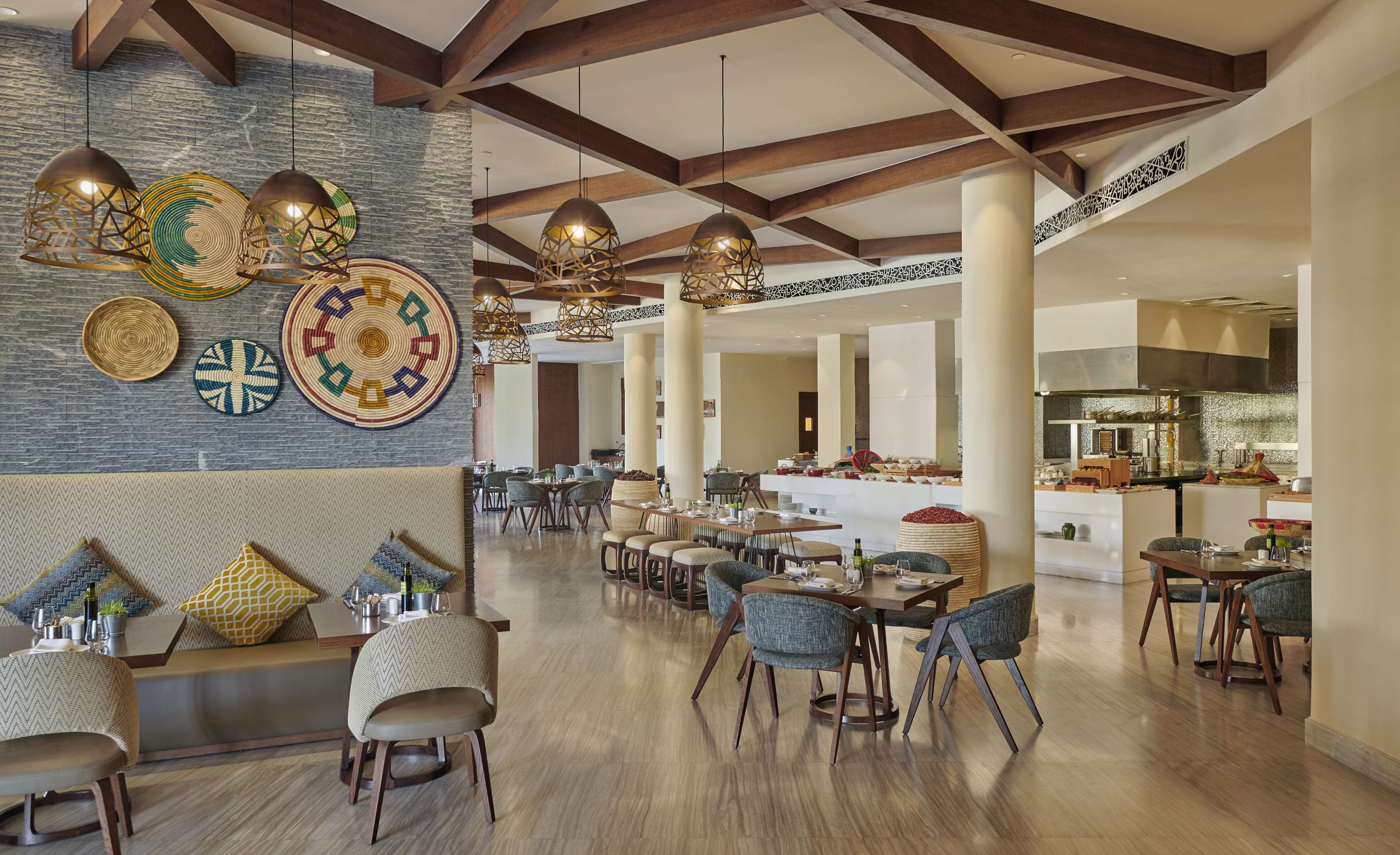 A spacious dining area with high ceilings, exposed beams, and modern pendant lighting.