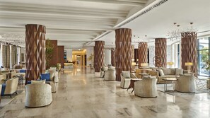 Experience a sophisticated lobby with high ceilings, geometric patterns, and comfortable seating areas.
