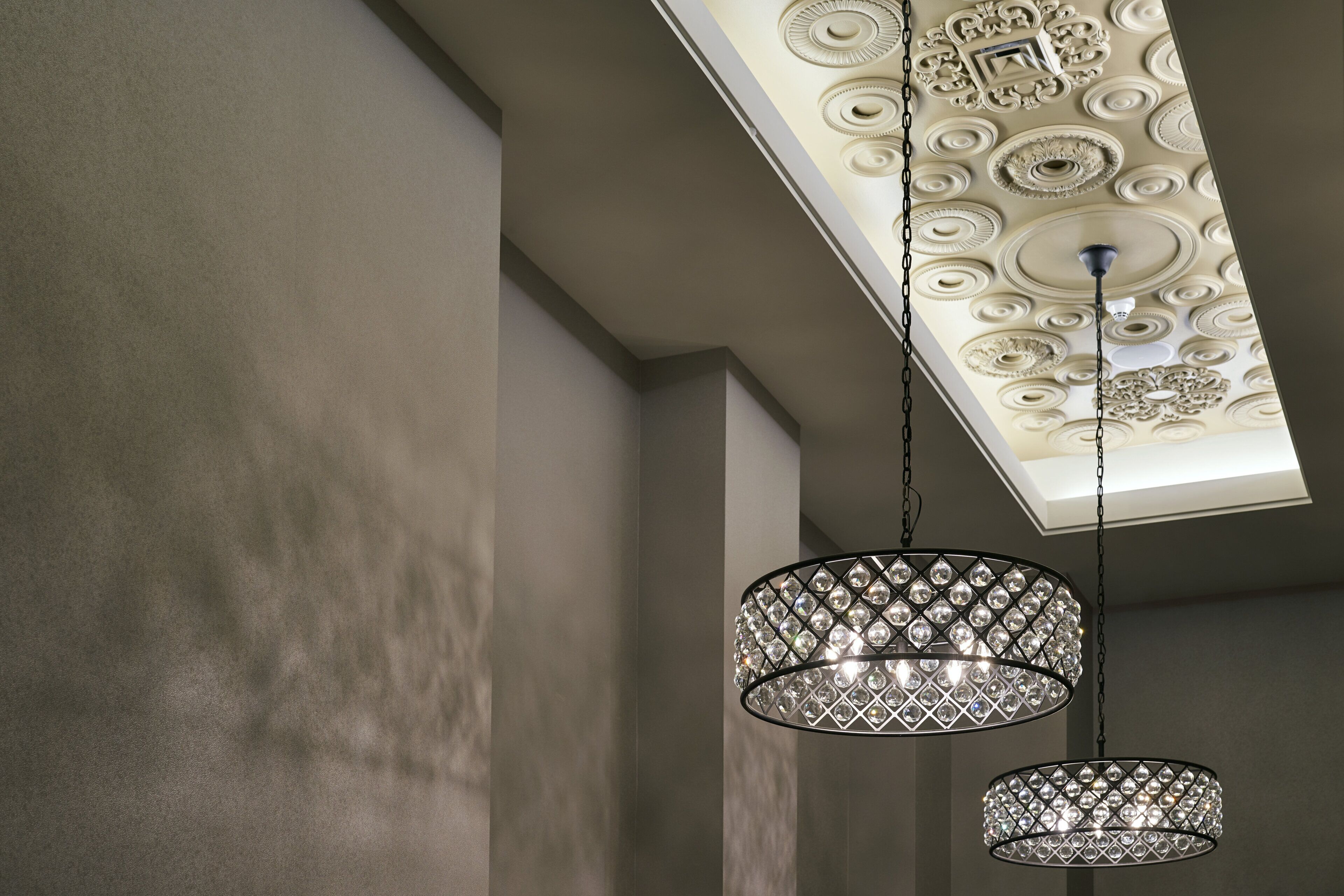 Techo con diseños decorativos y dos lámparas colgantes con un diseño de celosía de diamante.