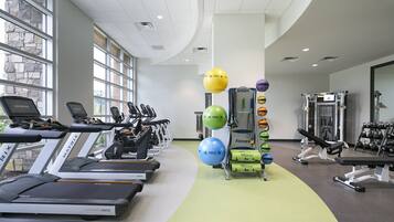 A gym with treadmills, exercise balls, and weight machines.