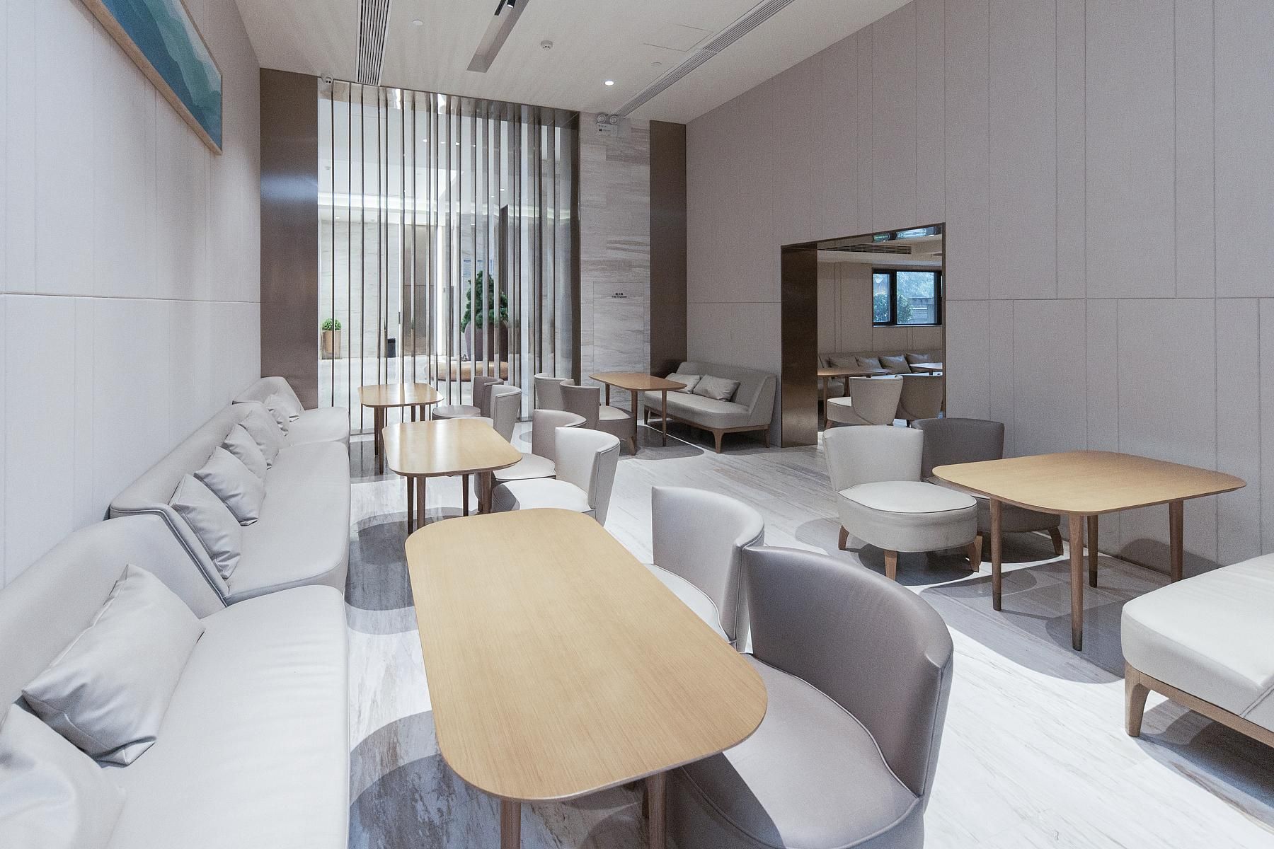 Un área de lounge moderna con sofás, mesas y sillas dispuestas para socializar.