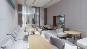 A modern lounge area with sofas, tables, and chairs arranged for socializing. - Ji Hotel (Huai'an)
