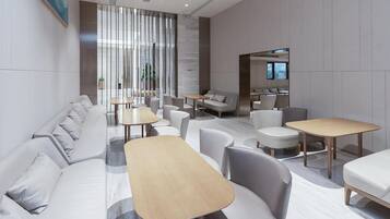 Un área de lounge moderna con sofás, mesas y sillas dispuestas para socializar.