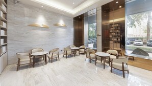 A modern lobby with marble flooring, wooden chairs, and bookshelves. - Ji Hotel (Huai'an)