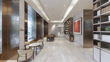 A modern interior with a dining area, bookshelves, and a large window.