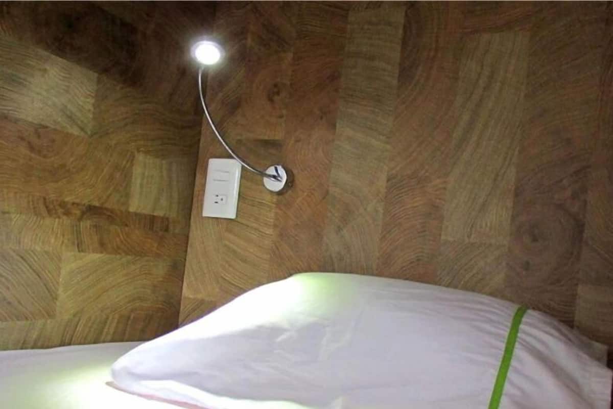 A wooden wall with a white switchboard and a single light fixture.