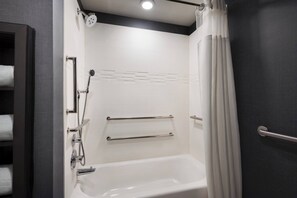 Une salle de bain moderne équipée d’une baignoire, d’une douche et de porte-serviettes.