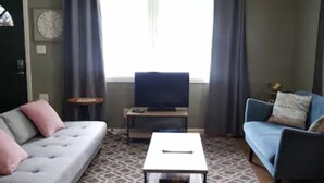 A living room with a grey sofa, a blue sofa, a coffee table, and a ceiling fan. - Go Braves!- 3bd/2ba 6min from Mercedes-Benz/CNN/GWCC (Atlanta)