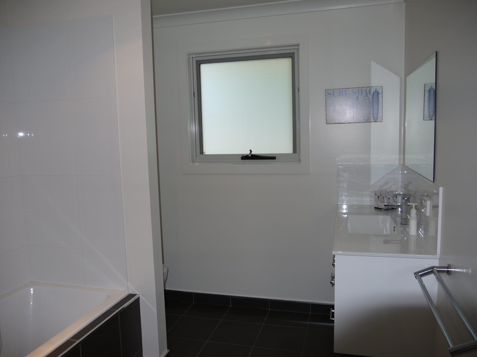 A bathroom with a bathtub, a toilet, a sink, and a window.