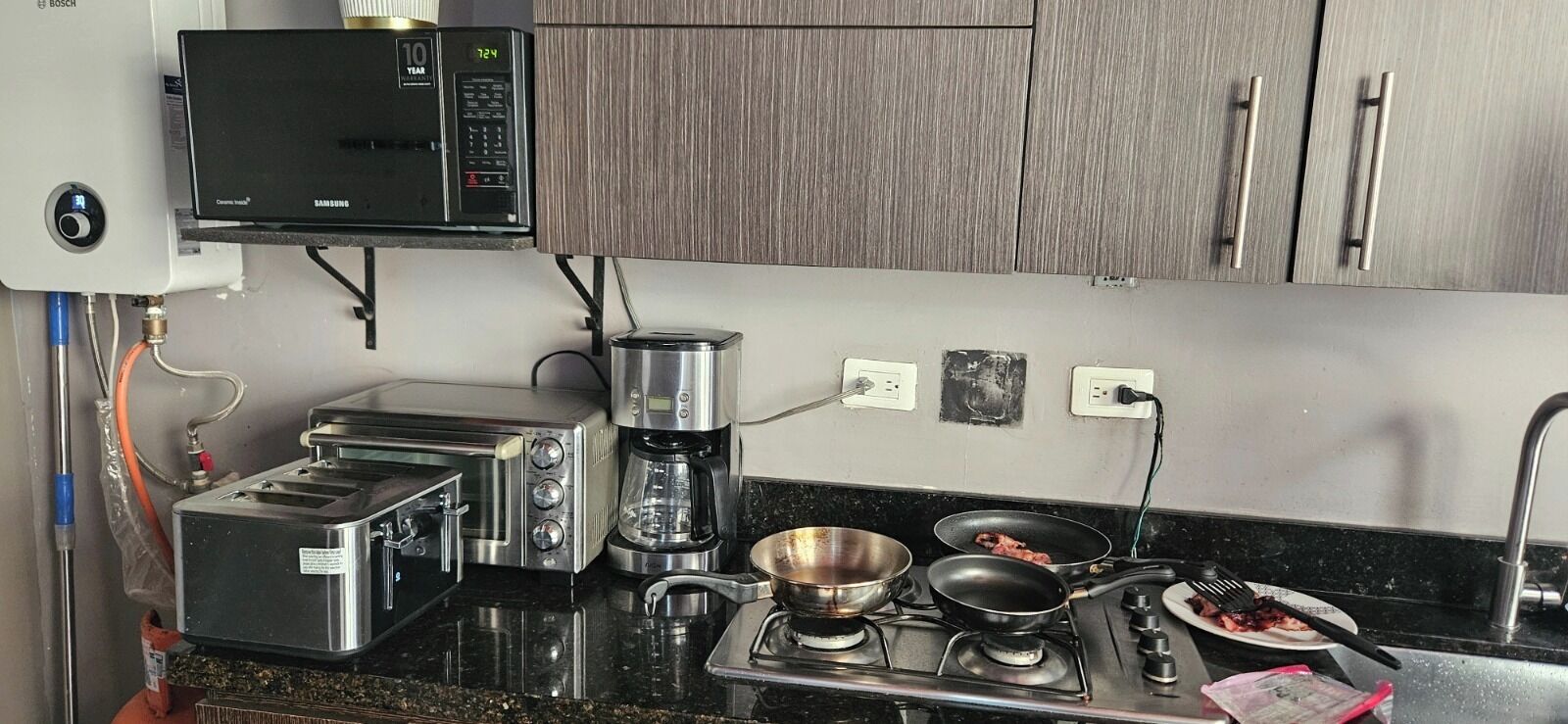 Eine Küche mit Mikrowelle, Toaster, Kaffeemaschine und Herd.