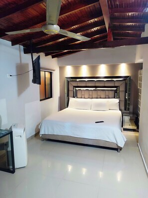 A bedroom with a bed, a ceiling fan, a TV mounted on the wall, and a bedside table. - $ PROMO $ 3 Bedrooms with Bathrooms apartment & Jacuzzi in Lleras park @Poblado (Medellín)