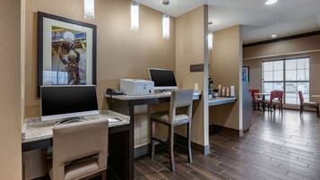 Eine Hotelhalle mit Empfangsschalter, Computern und einer Sitzecke.