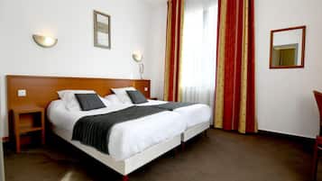 Un lit double avec deux oreillers, une table de chevet, une commode, un miroir et une fenêtre avec des rideaux rouges.