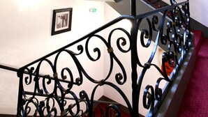 A staircase with ornate black metal railings and a skylight. - Logis Hotel du Chateau (Josselin)