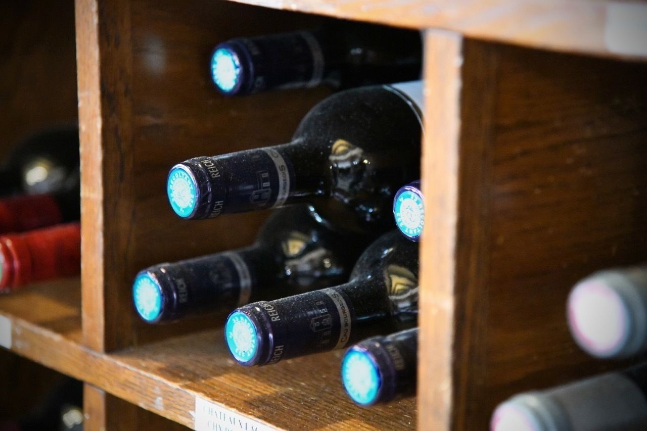Una estantería de madera con varias botellas de vino.