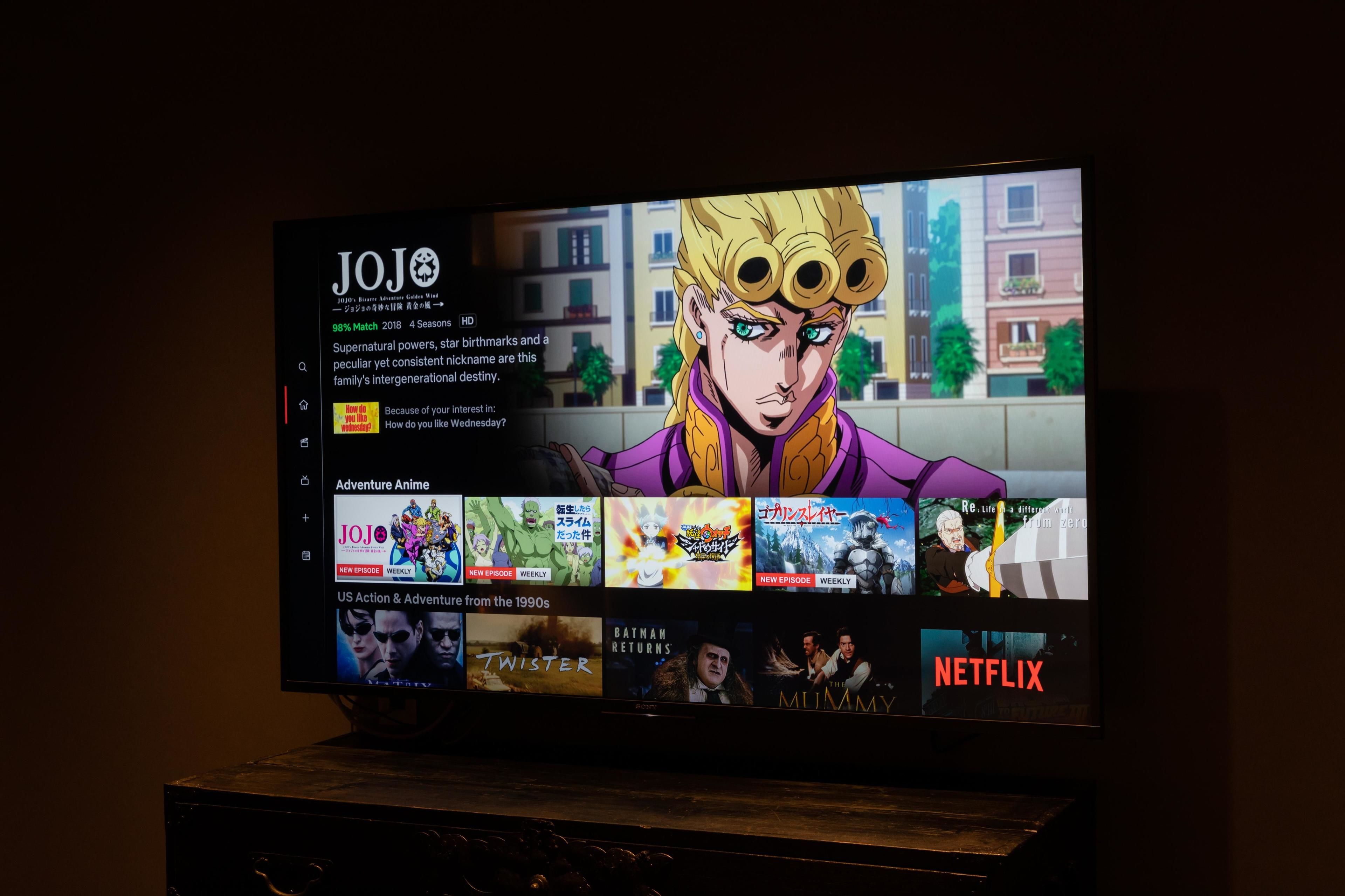 A television displaying a streaming service interface with anime and movie options.