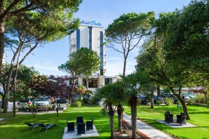 A hotel named 'Hotel Italy' with a modern building, a well-maintained garden with seating, and a parking area. - Hotel Italy (San Michele al Tagliamento)