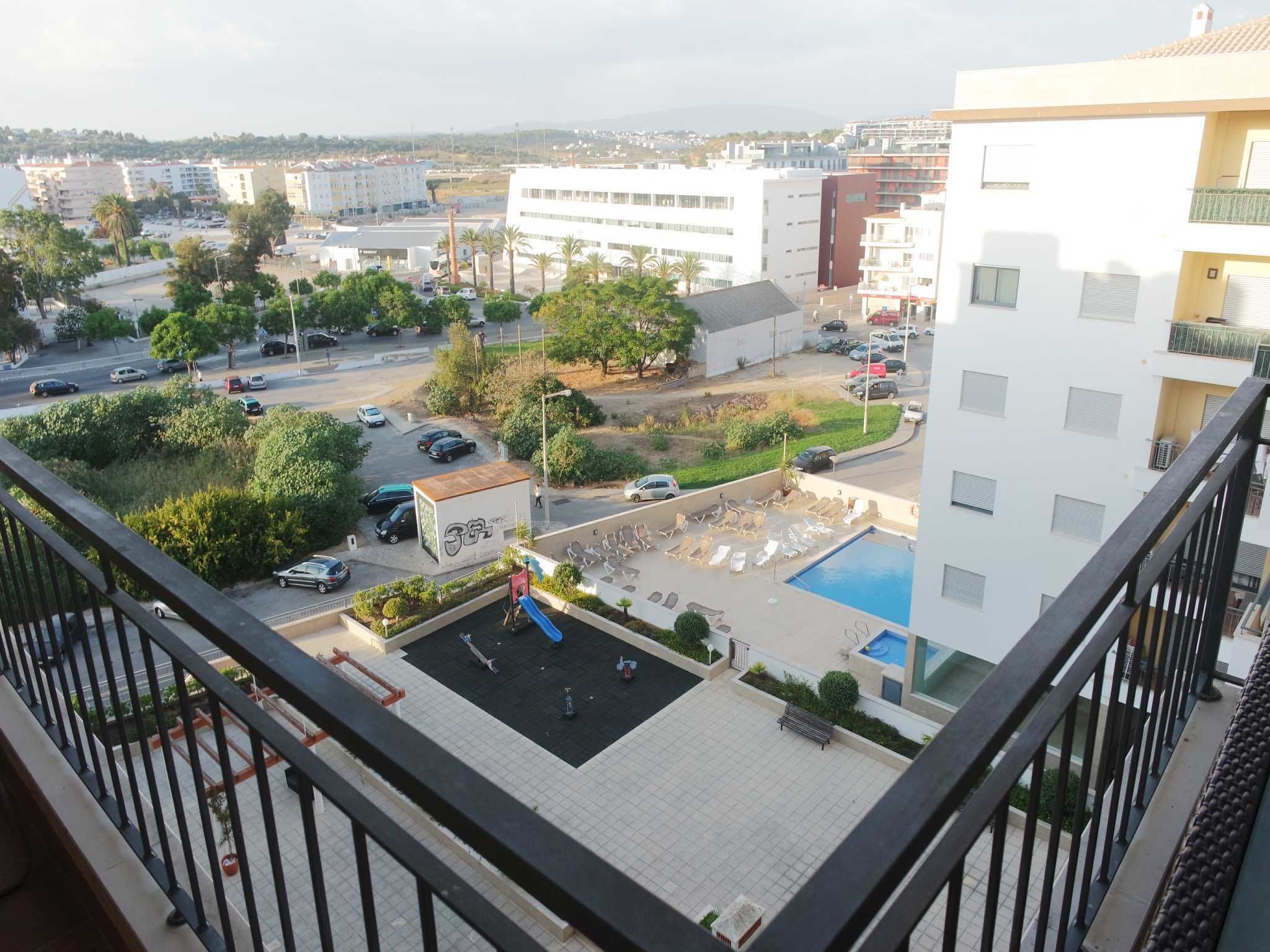 A residential area with a swimming pool, a playground, and a parking lot.