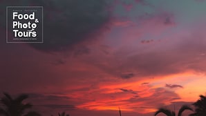 Eine Strandansicht mit Palmen und Sonnenuntergang.