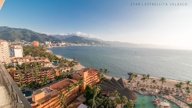 Ein Resort mit Poolbereich, direkt am Strand und mit Blick auf die Berge.