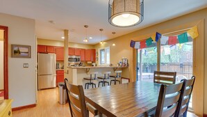 A spacious kitchen with wooden cabinets, a stainless steel refrigerator, and a dining area with a wooden table and chairs. - 2 Mi to Frisco Ski Hill: Mountain Home w/ Hot Tub! (Frisco)