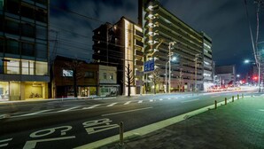 A nighttime city street with a bike lane, buildings, and streetlights. - RESI STAY BRiX (Kyoto)