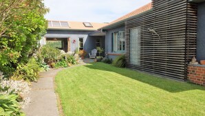 A residential building with a sloped roof, a covered porch, and a well-maintained lawn.