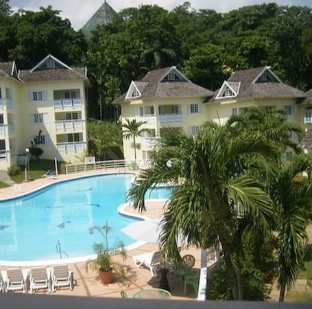 Una piscina al aire libre, sombrillas, guardavidas en la propiedad