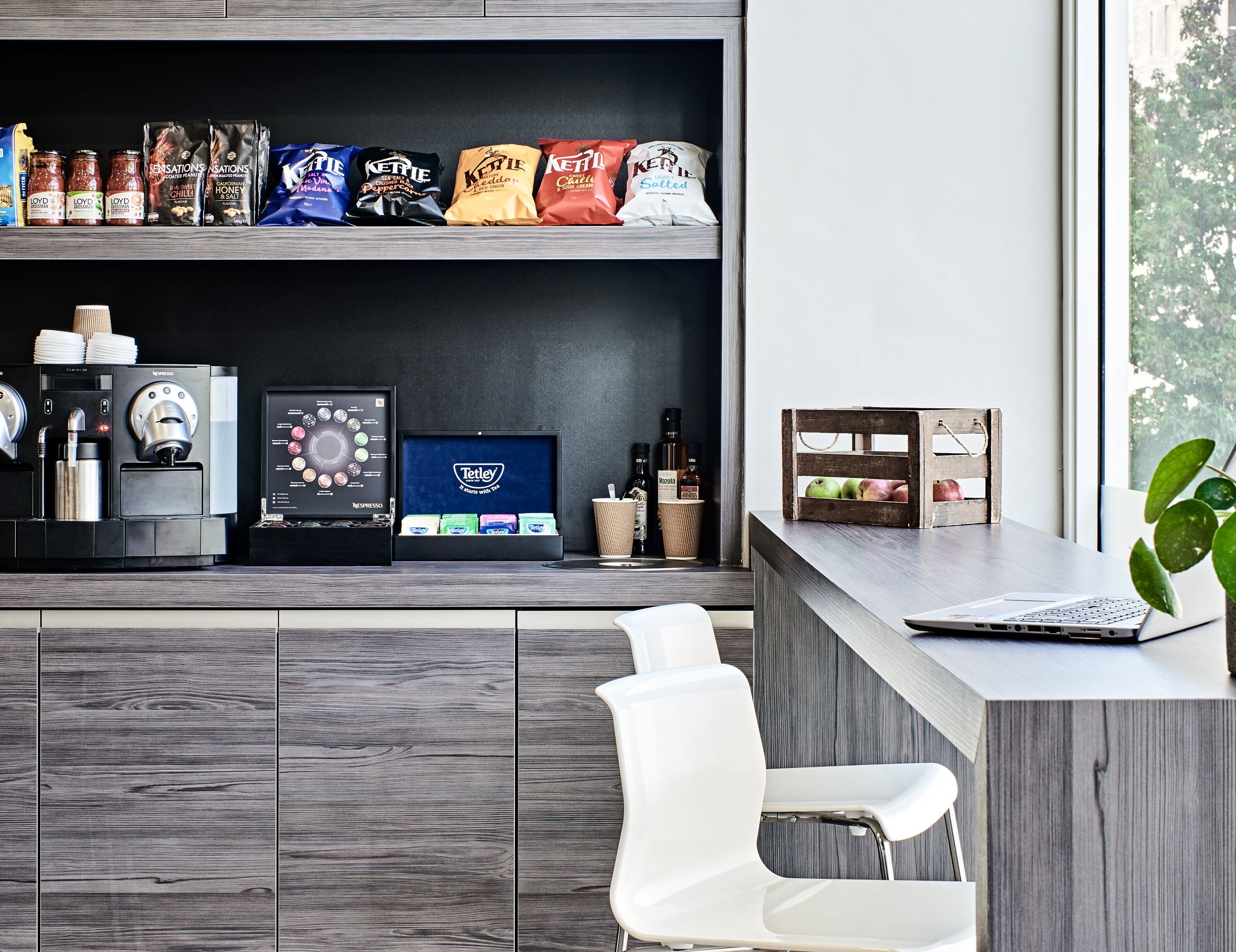 A modern coffee bar with a variety of coffee beans, a display of Tetley tea, and a Nespresso machine.
