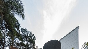 A modern building with large windows and a prominent cylindrical structure. - Foresta Hotel (Medellín)