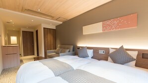 Ein Hotelzimmer mit einem großen Bett, einem Schreibtisch und einem Stuhl. Außerdem ist ein Kleiderschrank und ein Spiegel an der Wand vorhanden.